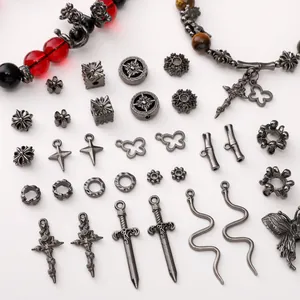 Macro view of Gothic metal beads, butterfly charms, and sword pendants for DIY jewelry making