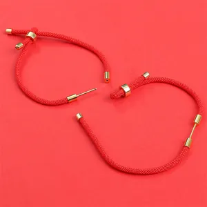 Détail de boucles d'oreilles faites à la main en corde tressée rouge avec fermoir doré