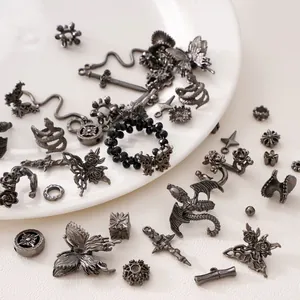 Detailed view of Gothic dark silver metal butterfly, dragon, and rose jewelry charms
