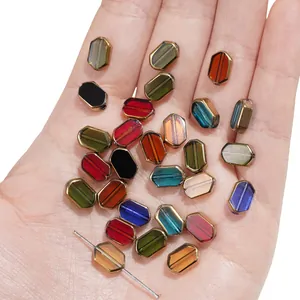 Handmade DIY rectangular crystal glass beads with gold trim shown in hand for scale