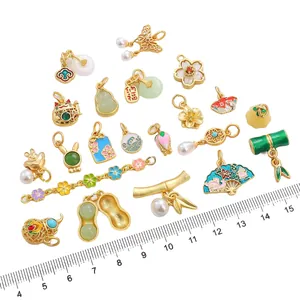 Golden fan and peanut charms for DIY jewelry making with ruler for size scale