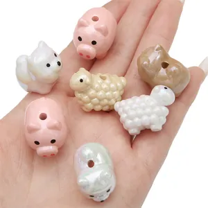 Dettaglio di perline colorate a forma di animali perlati per gioielli fai-da-te sulla mano