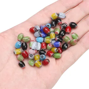Colorful Millefiori striped oval glass beads held in hand for DIY jewelry making