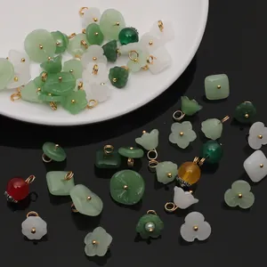 Macro detail of assorted glass jade pendant charms with gold metal rings for DIY jewelry