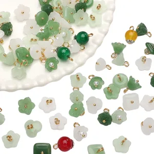 Close-up of assorted jade-style glass flower and bead charms with gold loops