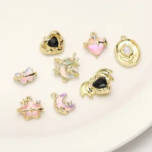 DIY-Schmuckanhänger mit rosa Herzchen, goldenen Sternen und Schmetterlingen auf einem Teller