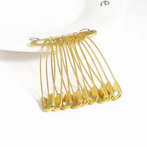 Set di 50 spille da balia dorate per cucito fai-da-te e segnapunti su piatto bianco