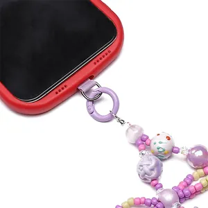 Detailed macro view of colorful beaded phone lanyard attached to a red case with purple ring