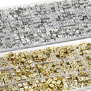Dettaglio di perline quadrate in acrilico con lettere oro e argento in scatola chiara