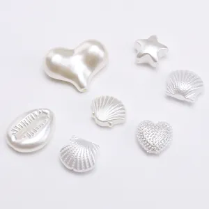Macro shot of pearl white heart, star and shell beads for DIY jewelry making accessories