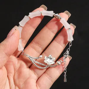 Detail showing pink barrel beads and silver lotus pendant on an adjustable bracelet