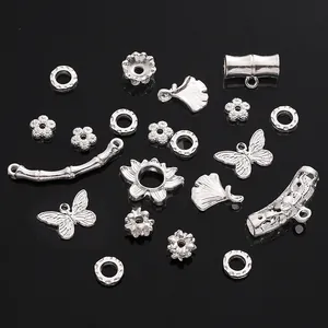 Detailed macro view of silver alloy DIY jewelry parts featuring butterfly and bamboo shapes