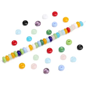 Macro shot of colorful jelly glass wheel beads strung on a white cord for DIY jewelry