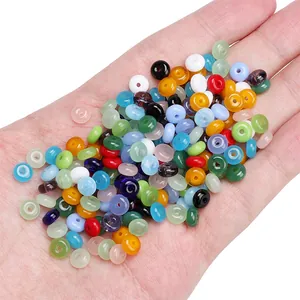 Colorful 6x3mm rondelle glass jelly beads for DIY jewelry held in a person's palm