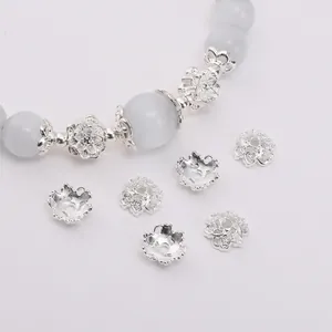 Copriperle a fiore argento per gioielli DIY con perle azzurre su sfondo bianco
