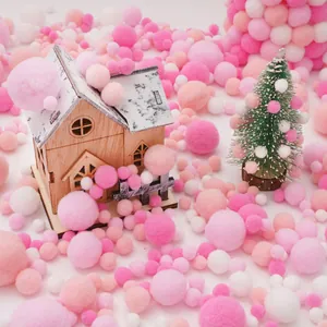 Miniature wooden craft house with pink and white plush pom poms for DIY handmade projects