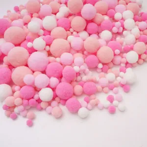 Detail of assorted pink and white soft plush pom-poms for DIY crafts and handmade accessories