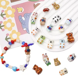 Detailed view of handmade ceramic animal beads and DIY bracelet with glazed pandas and koalas