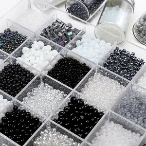 Macro shot of colorful DIY seed beads kit in transparent organizer box with glass bottles
