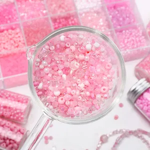 Pink glass beads set for DIY jewelry making with various shapes in storage containers