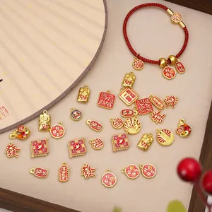 Close-up of Chinese New Year charms with red enamel and gold lucky characters on tray