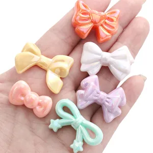 Close-up of pastel acrylic bow beads with pearlescent finish for DIY jewelry crafting
