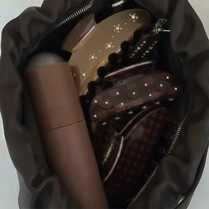 Dettaglio ravvicinato di fermagli per capelli in acetato con strass in borsa marrone