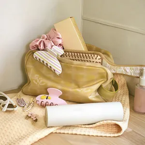 Dettaglio del set con pochette a quadri, elastico in seta, molletta e spazzola in legno