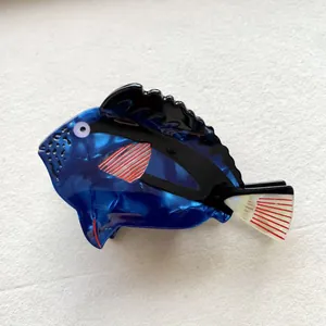 Detailed close-up of a blue tropical fish hair claw clip with a marbled acetate finish