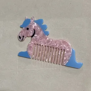 Dettaglio del pettine in acetato rosa a forma di pony con denti larghi