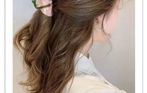 Close-up of pink marble acetate hair claw and pearl earrings worn by a model