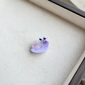 Macro view of a cute resin snail hair clip with a purple translucent shell texture