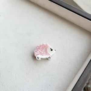 Detail of pink resin hedgehog hair clip in a beige fabric jewelry display box
