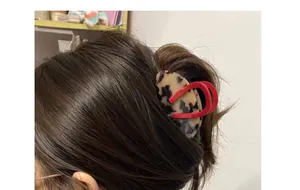 Side view of tortoise shell acetate hair claw with red accents on brown hair