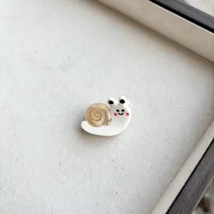 Detailed macro shot of a cute 3D resin snail hair clip on a premium jewelry tray