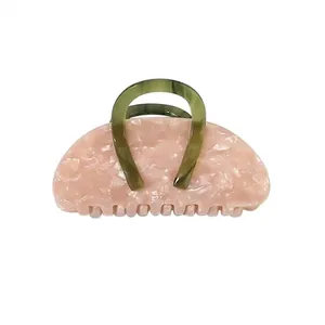 Floral acetate hair claw clip with pink base and olive green U-shaped handle