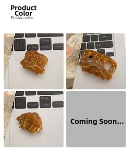 Détail de trois pinces à cheveux ambrées avec texture marbrée dorée sur un bureau plat