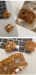Détail des pinces à cheveux croissant et bretzel en acétate écaille de tortue