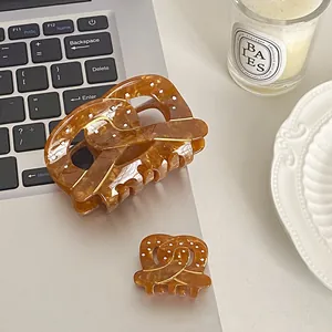 Pince à cheveux en acétate ambre en forme de bretzel avec motifs à pois blancs