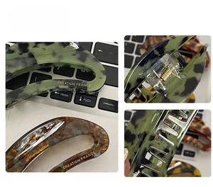 Detail view of large acetate hair claw clip with tortoise pattern and metal spring