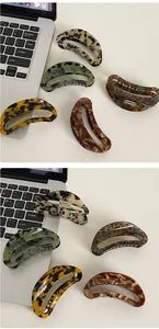 Macro detail of crescent acetate hair claws with marble and tortoiseshell textures