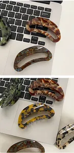 Detailed view of tortoiseshell acetate hair claws placed on a silver laptop keyboard
