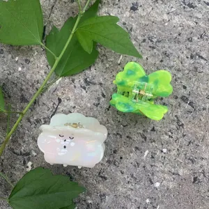 Charming acetate hair claws in cloud and lucky clover shapes on stone background
