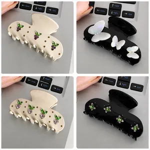 Detail view of four butterfly hair clips with rhinestones in cream and black colors