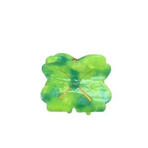 Mini four-leaf clover hair claw clip in green marbled acetate with gold metal accents