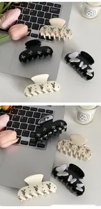 Detailed close-up of butterfly hair clips with rhinestones on a minimalist desk