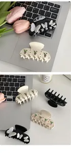 Detail of luxury rhinestone butterfly and fruit hair claws on a cozy desk background