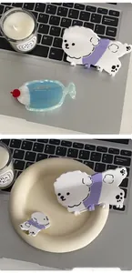Détail d'une pince à cheveux en acétate caniche blanc et accessoire poisson bleu