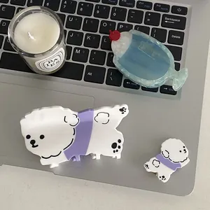 Lot de pinces à cheveux chien blanc en acétate et clip soda bleu sur un clavier