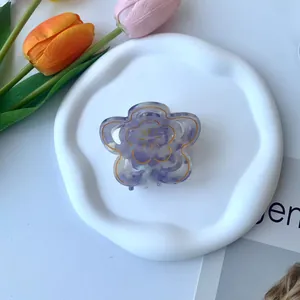 Dettaglio della pinza per capelli in acetato viola a forma di fiore con bordi dorati
